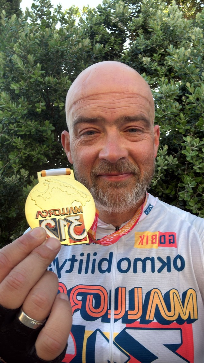 Gavin after completing Mallorca 312, holding his finisher medal